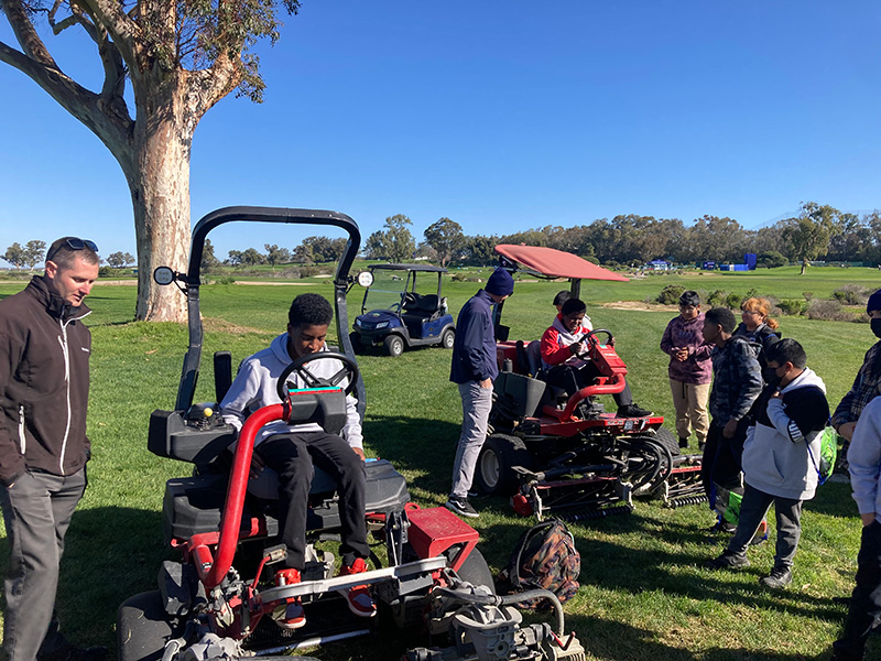 Students and Torrey Pines crew with riding mower