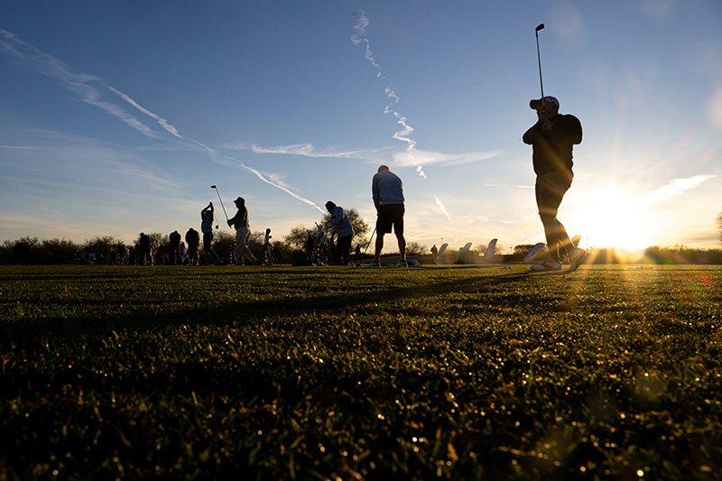 Backlit golfers teeing off during the 2024 GCSAA National Golf Championships