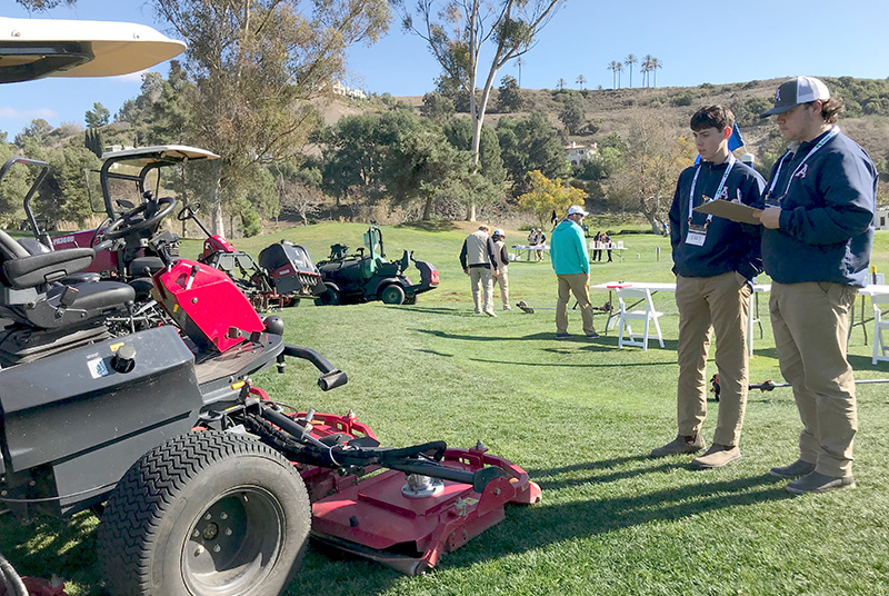 Two teenagers looking at a tractor outdoors