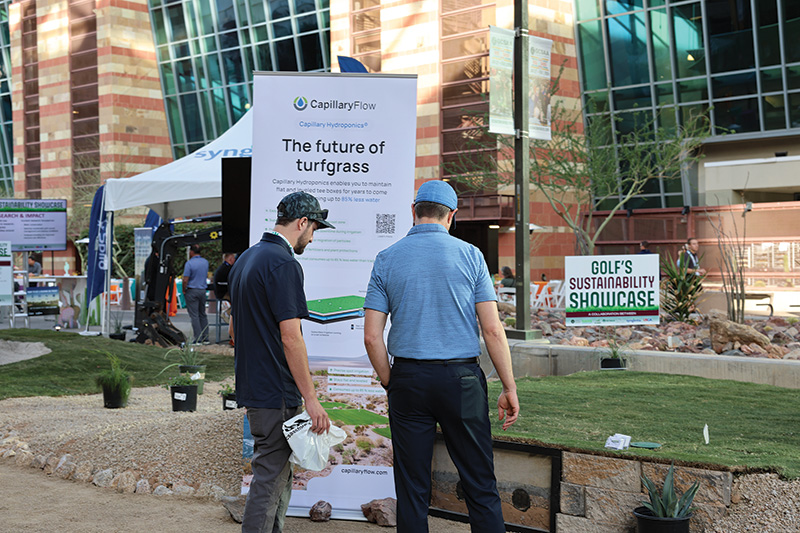 Two men explore an outdoor sustainability display at the 2024 GCSAA Conference and Trade Show