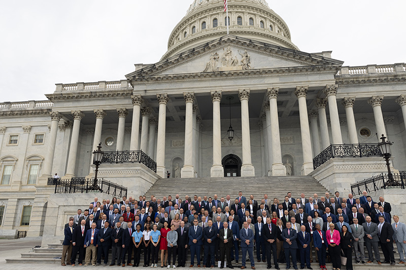 Group of people standing outdoors on the steps of the U.S. Capitol building
