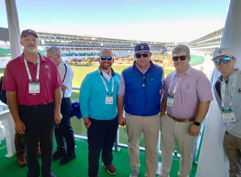 Brandon Reese standing with GCSAA members at the 16th hole at TPC Scottsdale