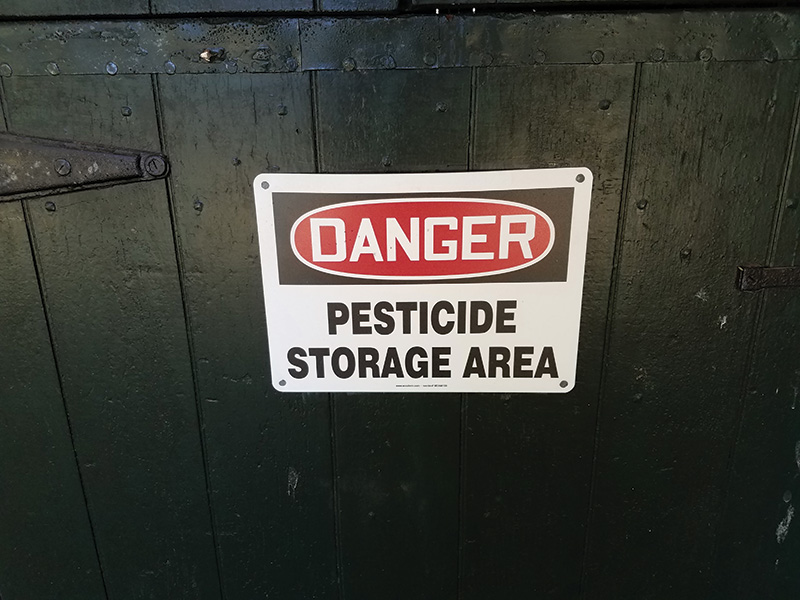 pesticide storage sign on black door