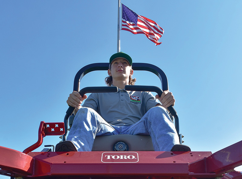 Bronco Deeds on a red Toro riding mower, shot from below