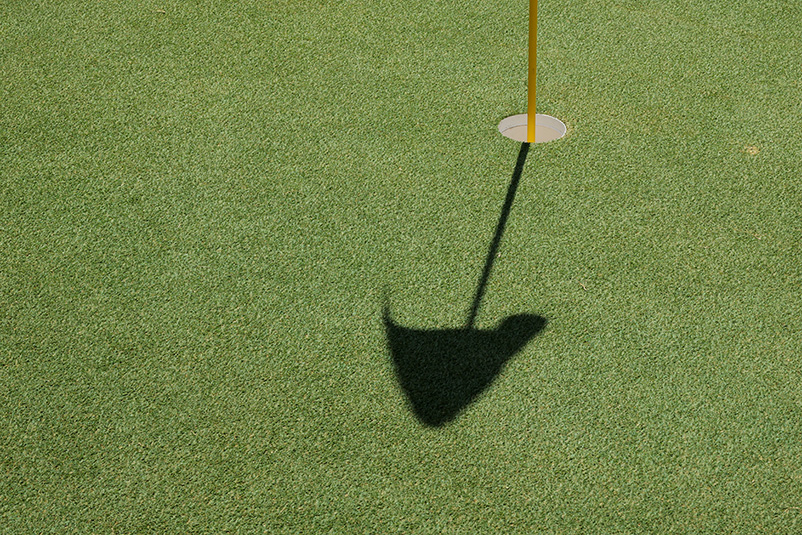 putting green with the shadow of a flag